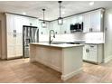 Modern kitchen featuring a center island, stainless steel appliances, and bright white cabinetry at 8825 Larwin Ln, Orlando, FL 32817