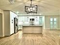 Bright kitchen with an island, stainless steel refrigerator, and pendant lighting at 8825 Larwin Ln, Orlando, FL 32817