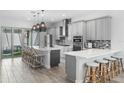 Bright, modern kitchen with quartz countertops, stainless steel appliances, large island with seating, and pendant lighting at 8848 Bismarck Palm Dr, Winter Garden, FL 34787