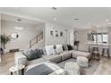 Spacious living room with plush sectional sofa, stylish decor, and modern open floor plan with view of staircase at 8848 Bismarck Palm Dr, Winter Garden, FL 34787