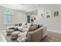 Inviting living room with large sectional sofa, decorative poufs, modern decor and bright natural light at 8848 Bismarck Palm Dr, Winter Garden, FL 34787