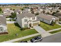 An aerial of a lovely two-story home featuring a well-maintained lawn in a quiet neighborhood at 889 Boxelder Ave, Minneola, FL 34715