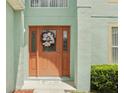 Close-up of a front door with decorative wreath in a light aqua home at 905 Cascade Falls Ln, Deland, FL 32720