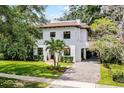 Stunning two-story home featuring a red tile roof, lush landscaping, and a porte-cochère at 906 Alhambra Ct, Orlando, FL 32804