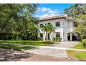 Elegant two-story home showcasing a manicured lawn and charming brick paved driveway at 906 Alhambra Ct, Orlando, FL 32804