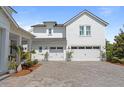 Spacious three-car garage showcasing white doors, a brick driveway, and meticulous landscaping at 907 Celadon St, Winter Garden, FL 34787