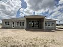 The rear exterior view of home under construction shows a covered patio and several windows at 960 Hawksnest Pt, Oviedo, FL 32765