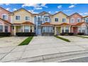 Charming townhomes featuring colorful exteriors, red-tiled roofs, and well-kept lawns in a serene community at 1180 S Beach Cir, Kissimmee, FL 34746