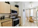 Eat-in kitchen featuring stainless steel appliances, wooden cabinets, and a cozy dining area with natural light at 1180 S Beach Cir, Kissimmee, FL 34746