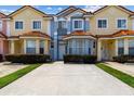 Row of colorful townhouses with red tile roofs, bay windows, and landscaped front yards on a sunny day at 1180 S Beach Cir, Kissimmee, FL 34746