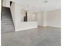 Bright and airy living space with staircase leading to upper level and open kitchen at 12307 Turtle Grass Dr, Orlando, FL 32824