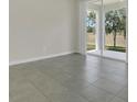Open-concept living room featuring ceramic tile flooring and sliding glass doors to the patio at 12307 Turtle Grass Dr, Orlando, FL 32824