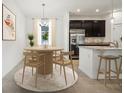A dining room with modern decor and a view of the kitchen, including stainless steel appliances at 1247 Blue Daze Ln, Eustis, FL 32726