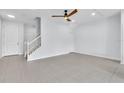 Bright and airy living room featuring tile floors, a ceiling fan, and a staircase at 1262 E 10Th St, Apopka, FL 32703