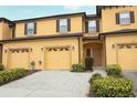 Inviting two-story townhouse featuring a two-car garage and manicured landscaping at 1441 Twin Trees Ln, Sanford, FL 32771