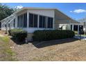 Inviting home with a sunroom and carport, enhanced by manicured shrubs for added privacy and curb appeal at 158 Rita Bee Ave, Davenport, FL 33897