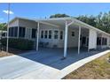Charming home with a covered carport and enclosed sunroom offering sheltered parking and outdoor living space at 158 Rita Bee Ave, Davenport, FL 33897