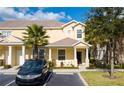 Inviting two-story townhome features a covered entryway, a car in the driveway, and lush landscaping at 17419 Placidity Ave, Clermont, FL 34714