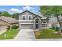 Inviting two-story home with manicured lawn, features a two-car garage and an arched entryway at 1758 Bobtail Dr, Maitland, FL 32751