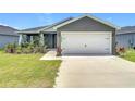 Beautiful single-story home with a two-car garage, manicured lawn, and freshly poured driveway at 2005 Noble Dr, Davenport, FL 33837
