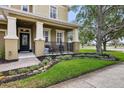 Inviting front porch with decorative railing, manicured landscaping, and a charming entrance to the home at 2116 Truffle Ln, Casselberry, FL 32707