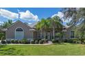 Charming single-story house boasts a lush green lawn, neat landscaping, and sunny skies at 2232 Lake Vilma Dr, Orlando, FL 32835
