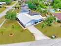 Overhead view of a single-story home, lush landscaping, long driveway, and spacious backyard with a screened in pool at 2369 Haulover Blvd, Deltona, FL 32738