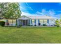 Charming single-story home with well-manicured lawn and garden beds, featuring blue shutters and a screened front porch at 2369 Haulover Blvd, Deltona, FL 32738