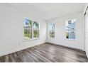 Bright bedroom with ample natural light from three windows and modern gray wood floors at 2378 Addalia Aly, Orlando, FL 32804
