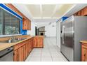 Open kitchen featuring wood cabinets, tile floors, stainless steel appliances, and an adjoining living space at 3379 Monika Cir, Orlando, FL 32812