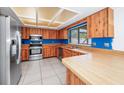 Spacious kitchen with stainless steel appliances, wood cabinets, and tile flooring offers a modern culinary space at 3379 Monika Cir, Orlando, FL 32812