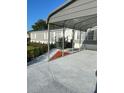 Exterior view of a single story home, showing a well-kept lawn and unique patterned driveway, with a convenient carport at 37518 Quail Ridge Cir, Leesburg, FL 34788