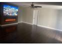 A living room featuring new flooring, a ceiling fan and a modern fireplace with a mounted television above at 37518 Quail Ridge Cir, Leesburg, FL 34788