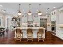 A bright and modern kitchen with a center island, pendant lighting, and stainless steel appliances at 3883 Grassland Loop, Lake Mary, FL 32746