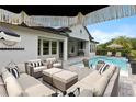 Stunning outdoor patio with luxurious pool and stylish seating with black and white accents at 3883 Grassland Loop, Lake Mary, FL 32746