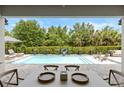 Beautiful view of the pool area from the outdoor dining area with comfortable lounge seating at 3883 Grassland Loop, Lake Mary, FL 32746