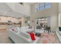 Bright living room featuring high ceilings, modern furniture, and sliding glass doors to the outdoor patio at 4772 Kings Castle Cir, Kissimmee, FL 34746