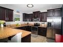 Kitchen featuring dark wood cabinets, stainless steel appliances, and stylish countertops at 4793 Grassy Knoll Dr, Tavares, FL 32778