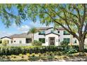 A beautiful, modern home with manicured landscaping and a stately, mature tree providing shade and character at 5525 Isleworth Country Club Dr, Windermere, FL 34786