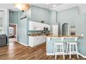 Open kitchen featuring white cabinets, granite countertops, a breakfast bar, and stainless steel appliances at 633 Lakehaven Cir, Orlando, FL 32828