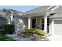 Charming front porch featuring a brick flower bed, white columns, and outdoor seating at 6350 Sedona Leaf Ct, Windermere, FL 34786