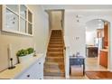 Bright home foyer with staircase, window, adjacent kitchen, and a tiled floor leading to the upper levels of the house at 7819 Hardenton St, Windermere, FL 34786