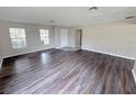 Spacious living room featuring wood floors, neutral walls, and natural light from two large windows at 786 Crystal Bay Ln, Orlando, FL 32828