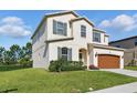 Charming two-story home with a well-maintained lawn, a two-car garage, and attractive architectural details at 1018 Boxelder Ave, Minneola, FL 34715