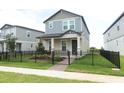 Inviting two-story home featuring a landscaped yard and a modern black fence, exuding suburban charm at 12272 Bracco St, Winter Garden, FL 34787