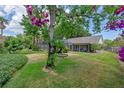 Lush backyard with a mature tree and swing provides a serene retreat with a screened-in porch at 1440 Suzanne Way, Longwood, FL 32779