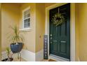 Welcoming front door is adorned with a wreath and potted plants at 1570 Barking Deer Cv, Casselberry, FL 32707