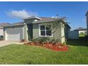 Charming single-story home featuring a well-manicured lawn and a two car garage at 1596 Park Side Ave, Kissimmee, FL 34744