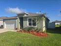 Charming single-story home featuring a well-manicured lawn and a two car garage at 1596 Park Side Ave, Kissimmee, FL 34744