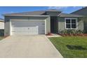 Charming single-story home featuring a well-manicured lawn, two car garage, and inviting front entrance at 1596 Park Side Ave, Kissimmee, FL 34744